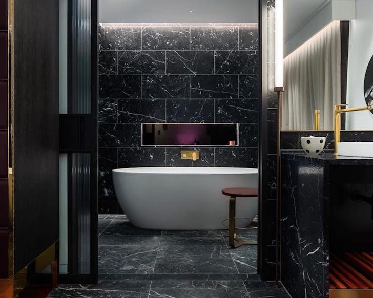 a black marble bathroom with big tub