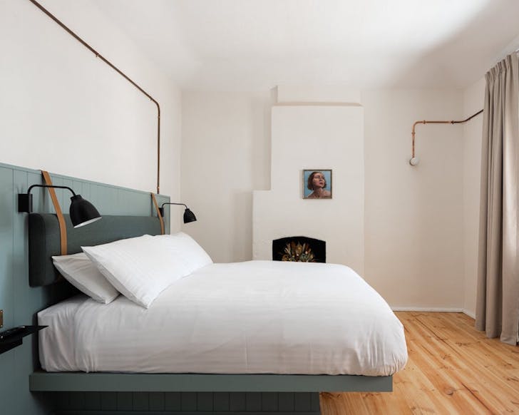 timber floored hotel room with bed at The Warders Hotel