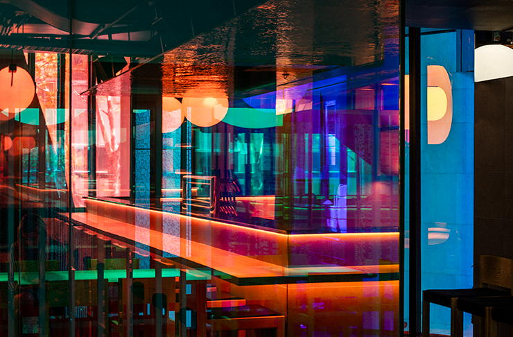 Bright neon lights surround an open kitchen at one of the best Japanese restaurants Melbourne has to offer, Yakimono.