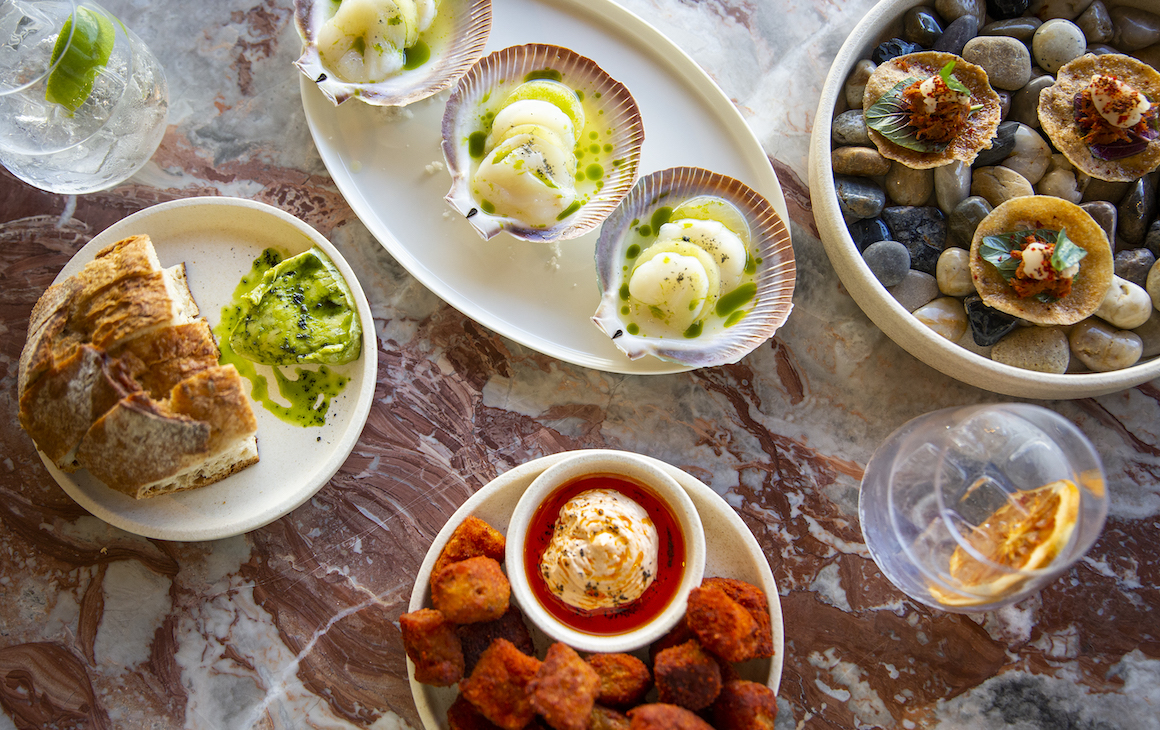 a view from above of a marble table filled with dishes and drinks