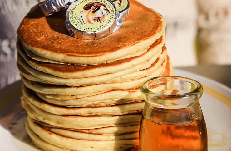 A stack of pancakes topped with Pepe Saya butter. 