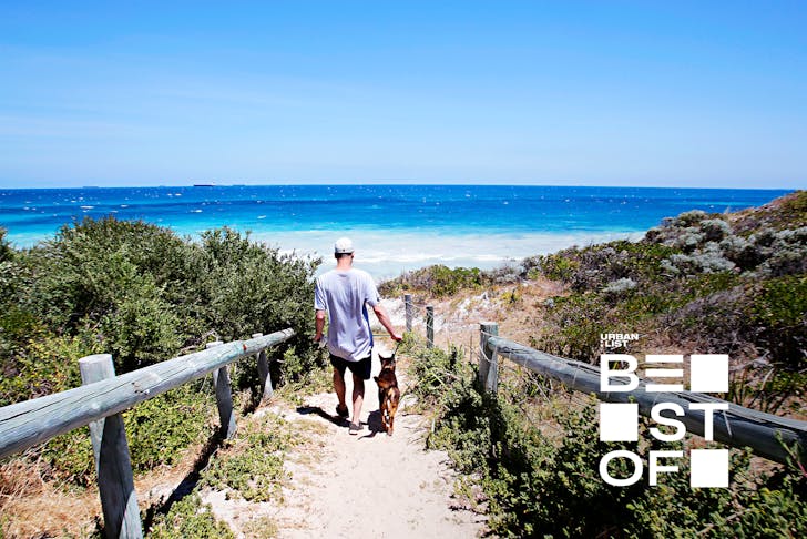 A man and his dog walking at one of the best beaches in Perth.