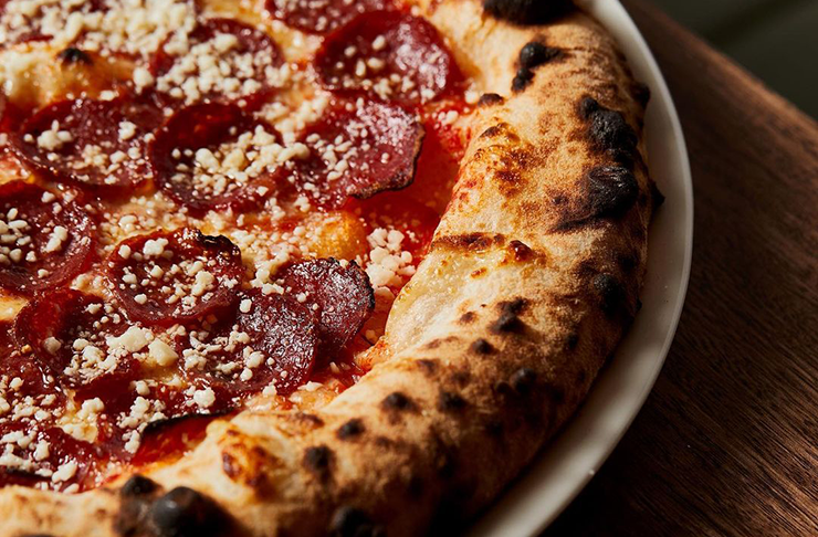 A close-up of a slice of cheese covered pizza at Capitano, considered some of the best Pizza in Melbourne.