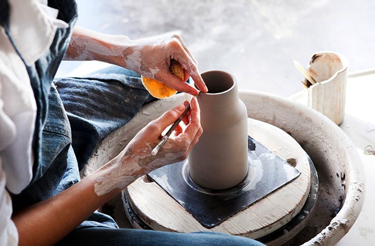 Person using pottery spinning wheel to create a vase at one of the best pottery classes in Perth