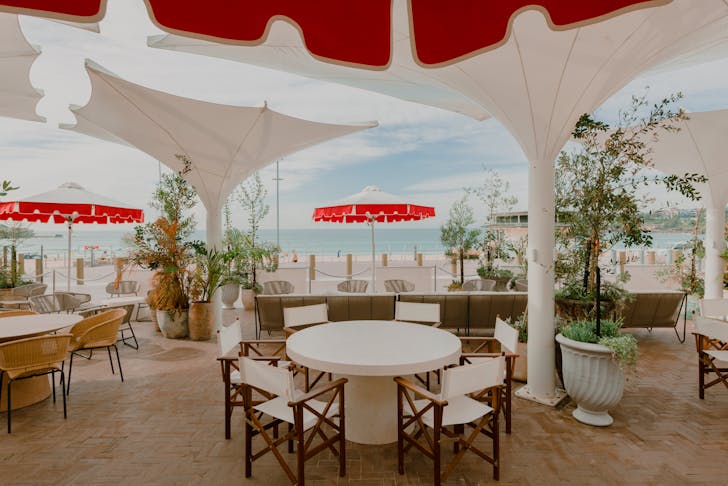 Red and white umbrellas on the terrace at Promenade Bondi Beach, one of the best restaurants in Bondi