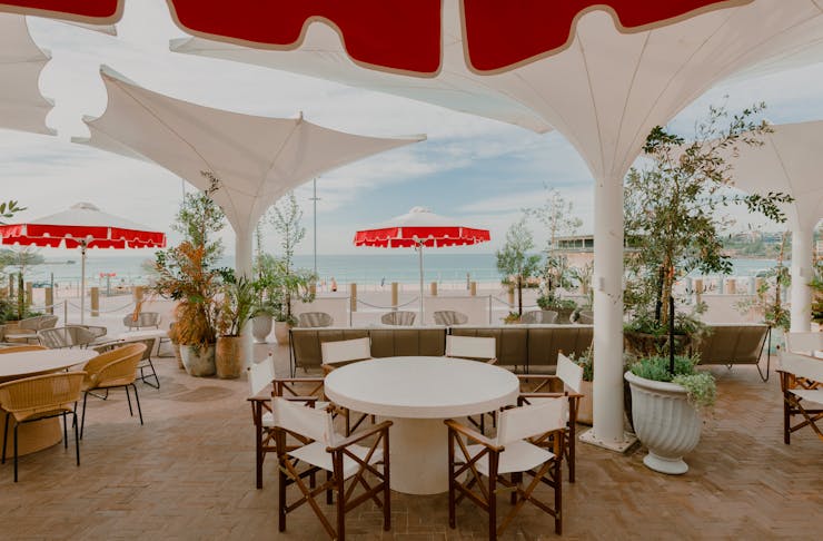 Red and white umbrellas on the terrace at Promenade Bondi Beach, one of the best restaurants in Bondi