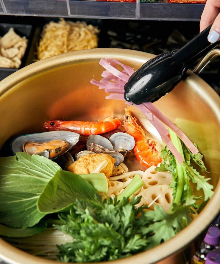 A large bowl of hot pot with seafood at a best late-night eats Melbourne restaurant. 