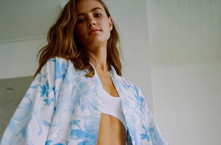 A women dressed in a blue and white silk robe from the label Dream With Me. 