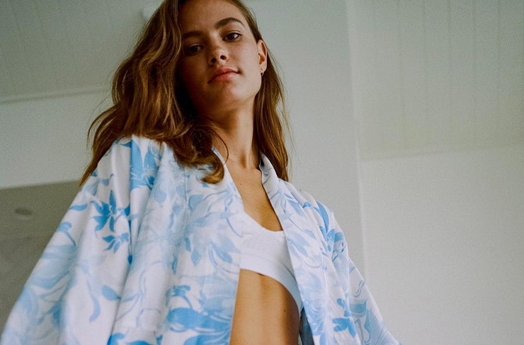 A women dressed in a blue and white silk robe from the label Dream With Me. 