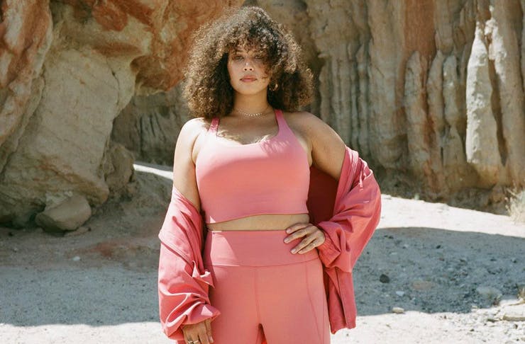 A model wearing a peach-coloured activewear set from sustainable label, Girlfriend. 