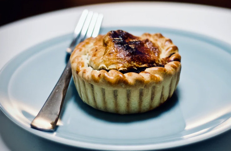 A vegan pie served on a blue plate with a fork. 