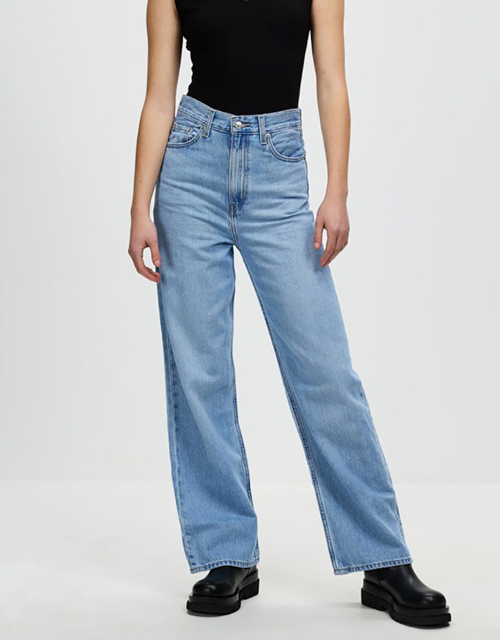 Some of the best wide leg jeans available for 2021, coloured light blue and sitting loosely on a model..