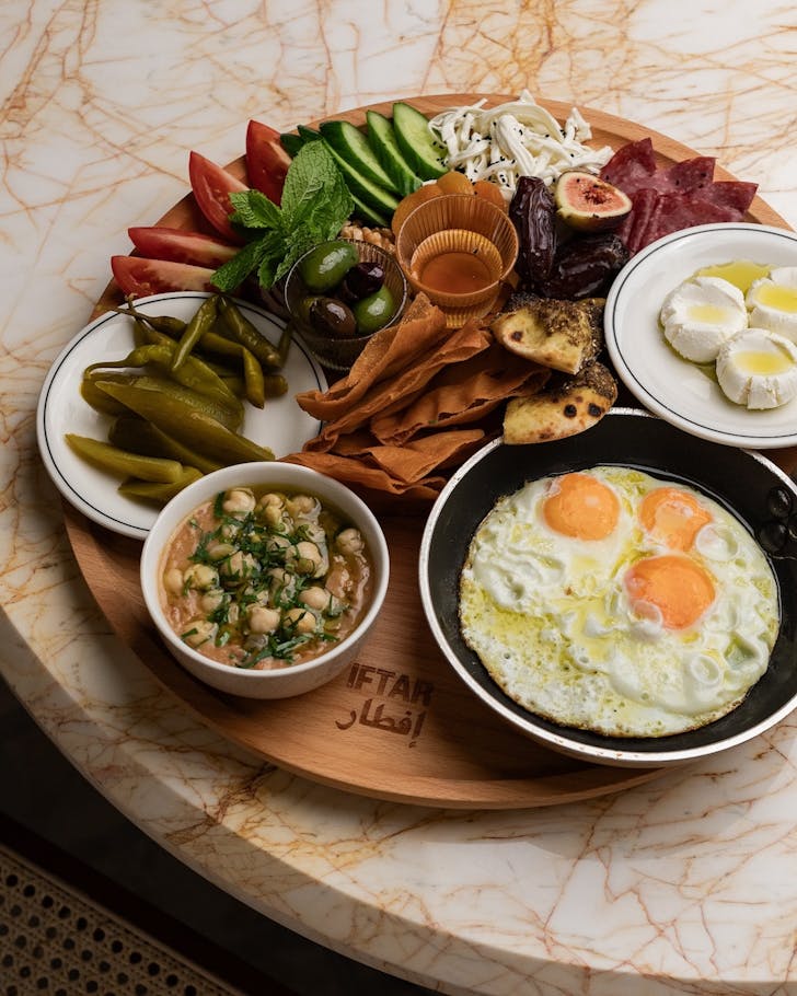 a massive middle eastern brunch spread with eggs, vegetables flatbread, fruit, yoghurt and more