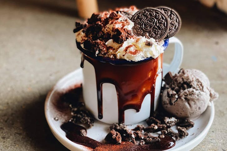 a decadent hot chocolate topped with cream and oreo cookies
