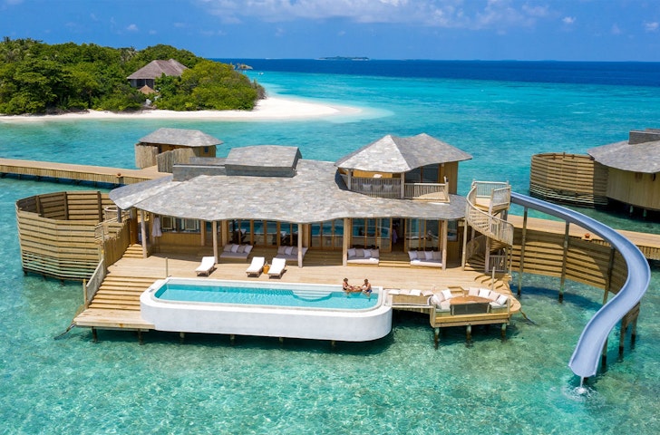 A view of a villa with a waterslide at Soneva Fushi one of the best Maldives hotels