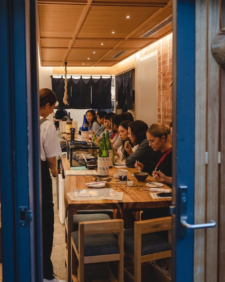 people sitting at the counter inside a tiny sydney japanese restaurant