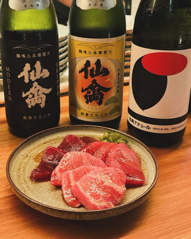 a plate of sashimi at amuro japanese in darlinghurst, with three bottles of sake