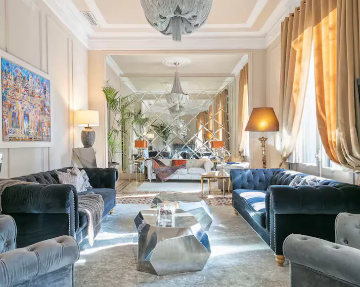 The expansive, lavish living area of a Barcelona Airbnb, with rich textures and fabrics.