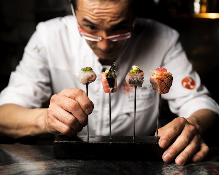 a japanese chef places omakase bites