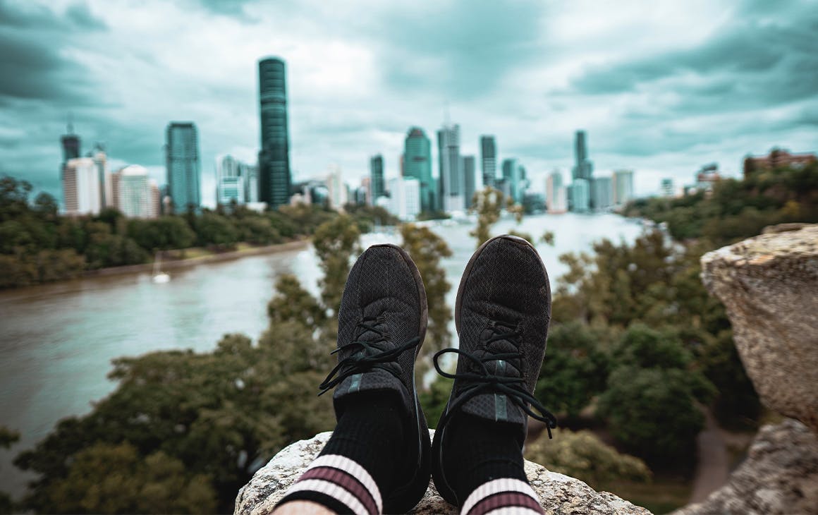 view of two feet extended out in front of a person in front of the city skyline at Kangaroo Point