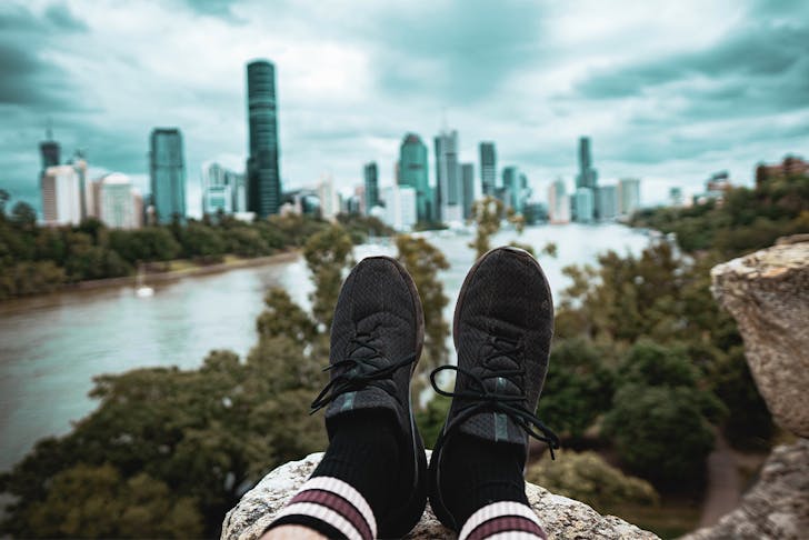 view of two feet extended out in front of a person in front of the city skyline at Kangaroo Point