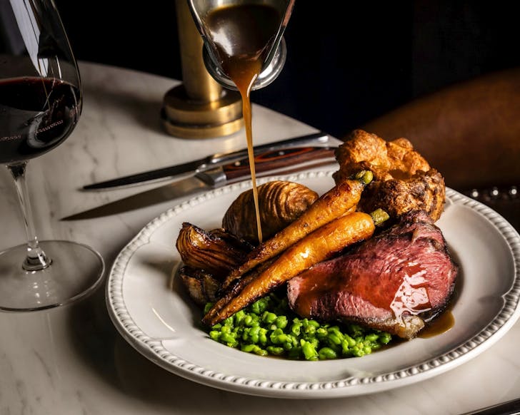 sauce is poured over the elegant sunday roast at the cut bar and grill in the rocks