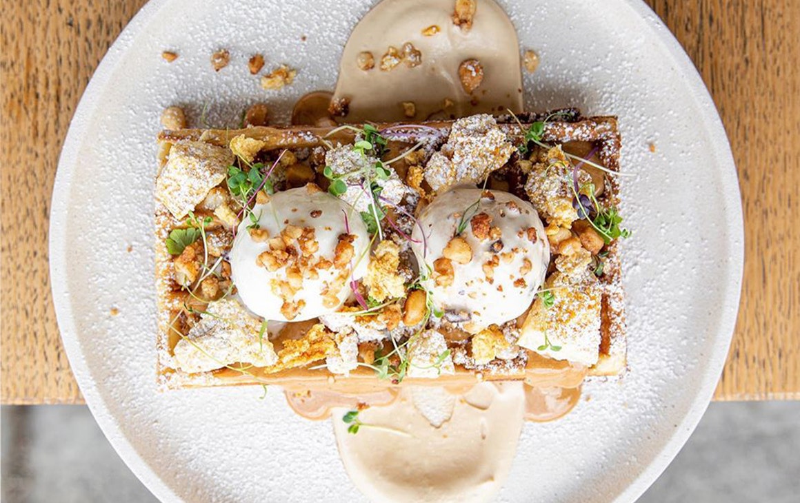 A waffle topped with ice cream and sauce