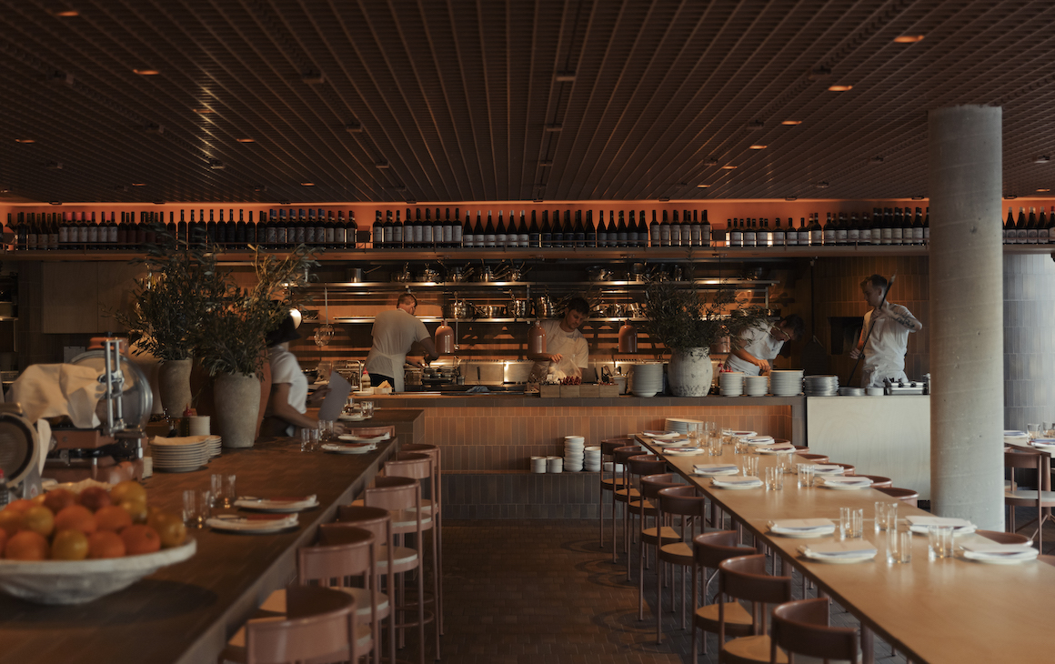 a peach-hued contemporary dining space with long tables