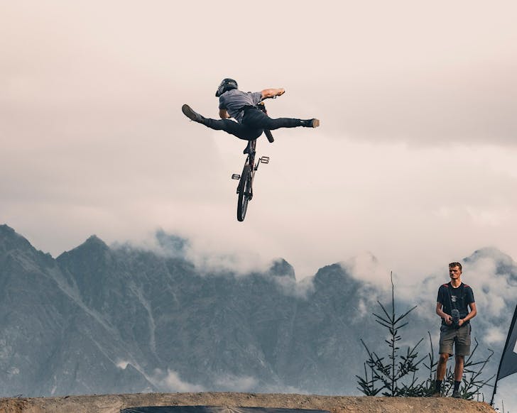 Someone does a gnarly trick on a bike.