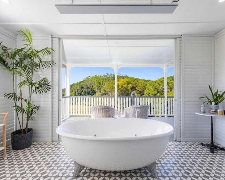 A view of the white bath with a view over the countryside at Bird Song Valley Airbnb near Brisbane Queensland