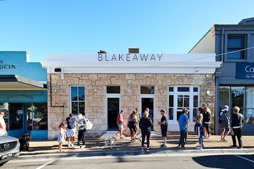 People standing out the front of a cafe with the signage