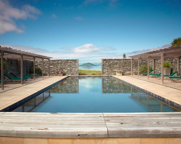 A stunning swimming pool looks out onto the mountains at Blanket Bay, one of the best luxury hotels in new zealand.