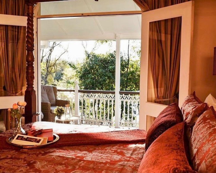 a victorian-style bedroom with french doors overlooking the garden
