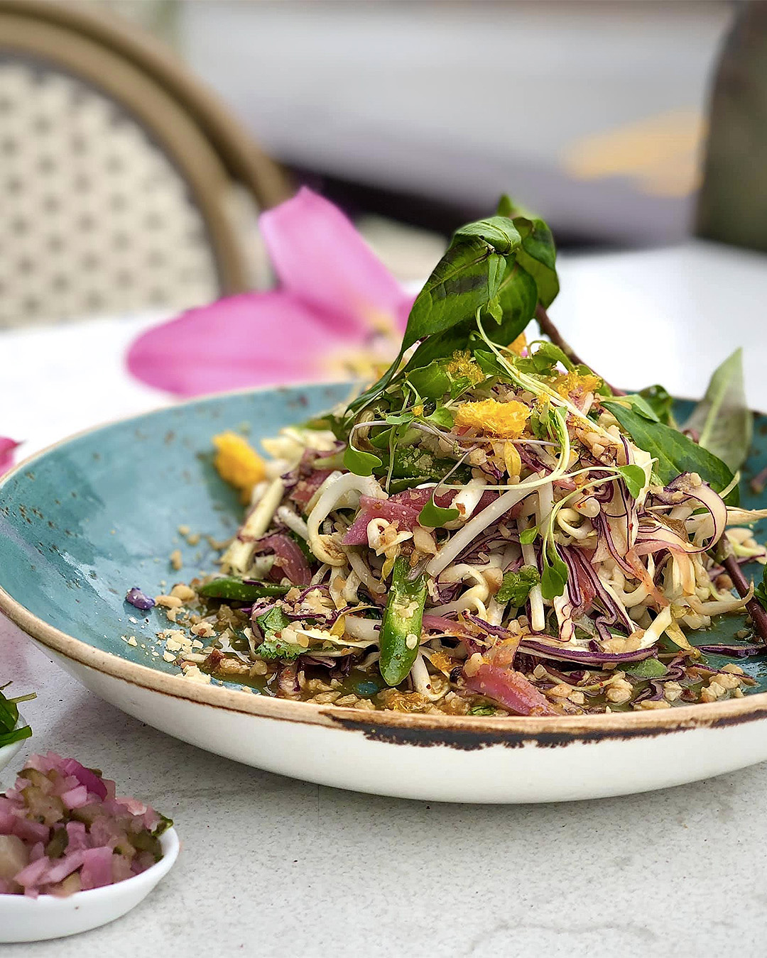 Shaved Red & Green Cabbage is tossed together with Sliced Green Beans, Candied Crumbled Peanuts, Mung Bean Sprouts and Pickled Carrots. Dressed in an Orange, Lime and GF Soy Sauce and topped with Crispy Mandarin Segments at Blue Kanu.