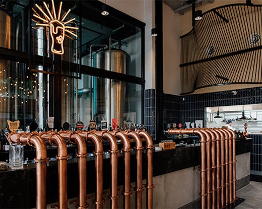 the interior of a brewpub, with copper beer taps