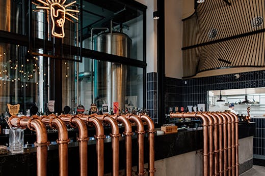 the interior of a brewpub, with copper beer taps