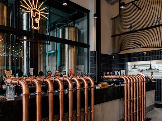 the interior of a brewpub, with copper beer taps
