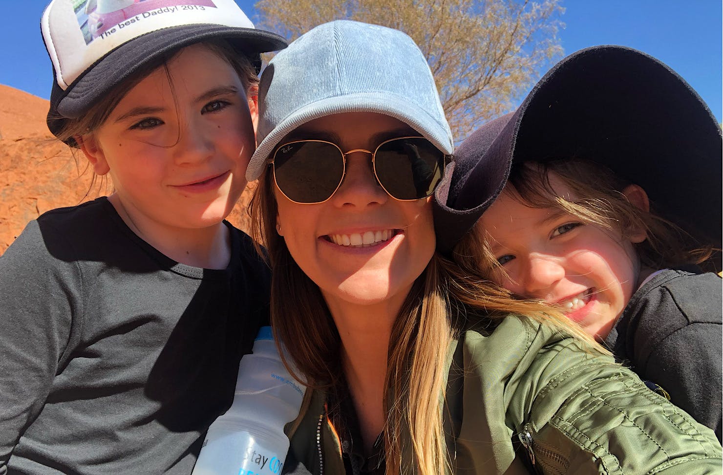 Bonnie and two little kids wear caps and look happy.