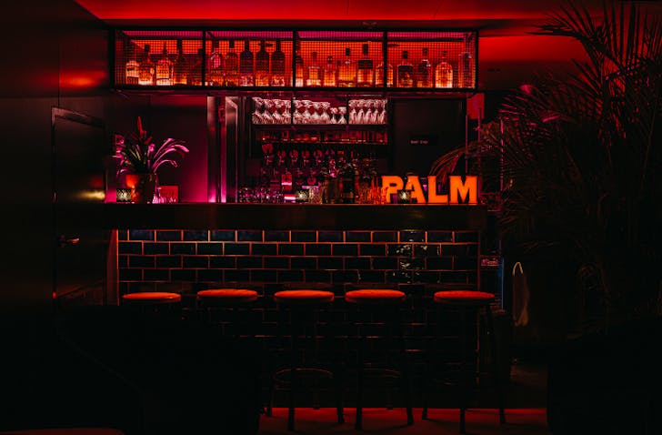 A late night bar lit up with neon red lights.