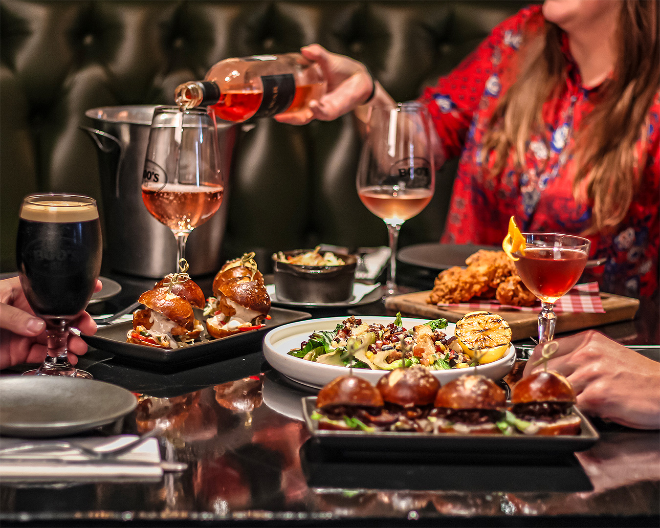 People sit around a table laden with food at Boo's, one of the best bars in Christchurch.