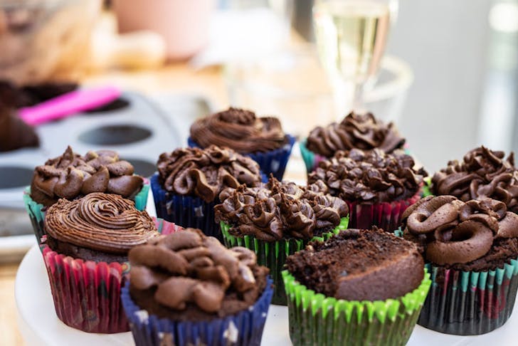 Chocolate cupcakes with a glass of champagne in the background. 