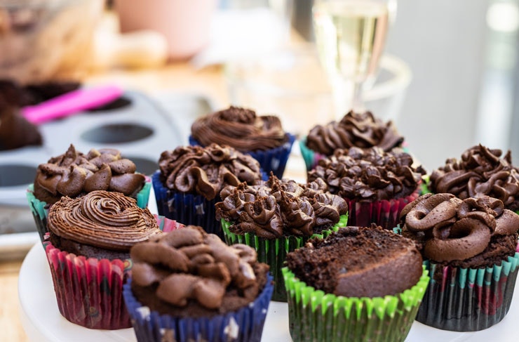 Chocolate cupcakes with a glass of champagne in the background. 