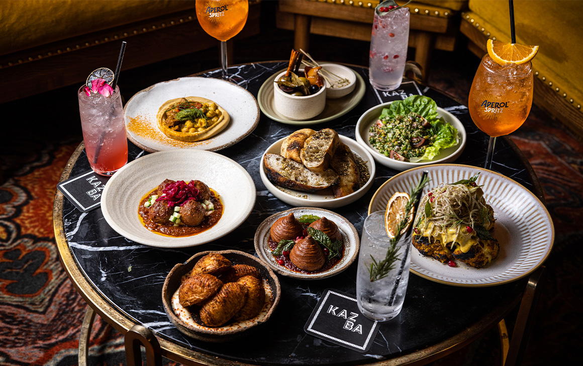 a table full of food and drinks at bar kazba for bottomless brunch