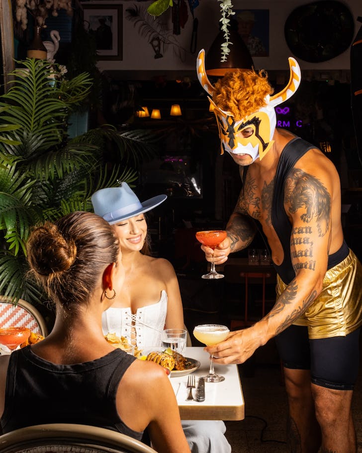 a luchadore serving cocktails at la farmacia's mexican bottomless brunch
