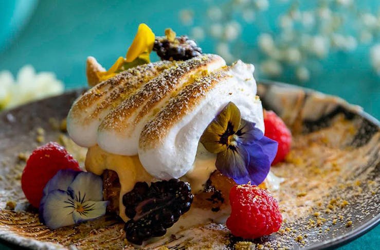 A close-up shot of a colourful lemon curd and meringue dish.