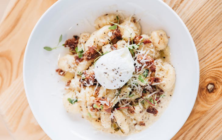 a bowl of gnocchi topped with a poached egg