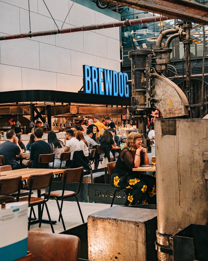 People sit around large shared tables at Brewdog South Eveleigh 