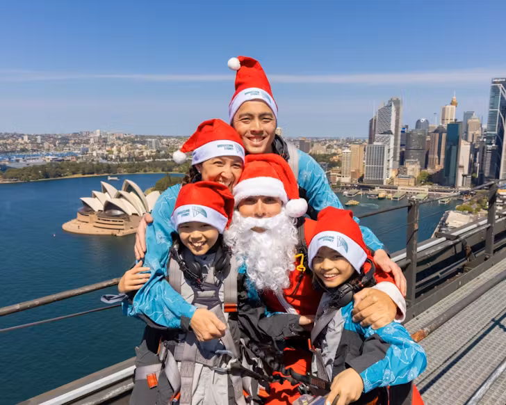 A family dresses in Santa hats for the Bridgeclimb Santa photos
