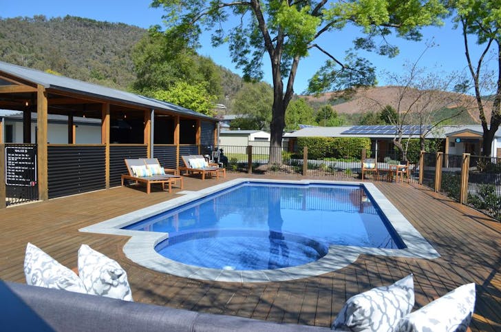 A motel pool set in front of several mountains.
