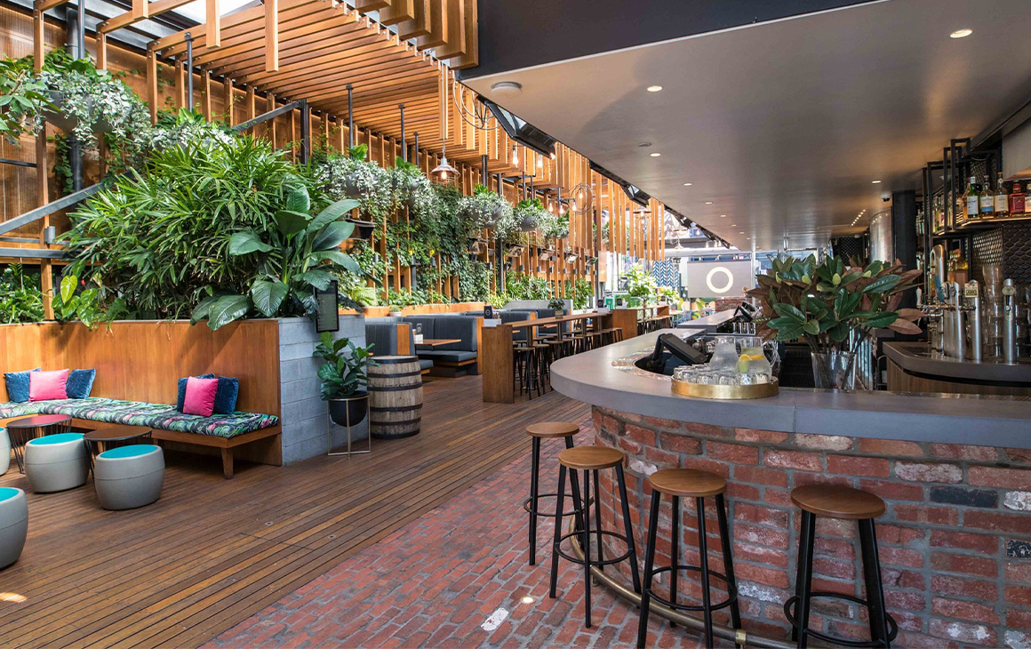 a beer garden with wooden walls and lots of plants